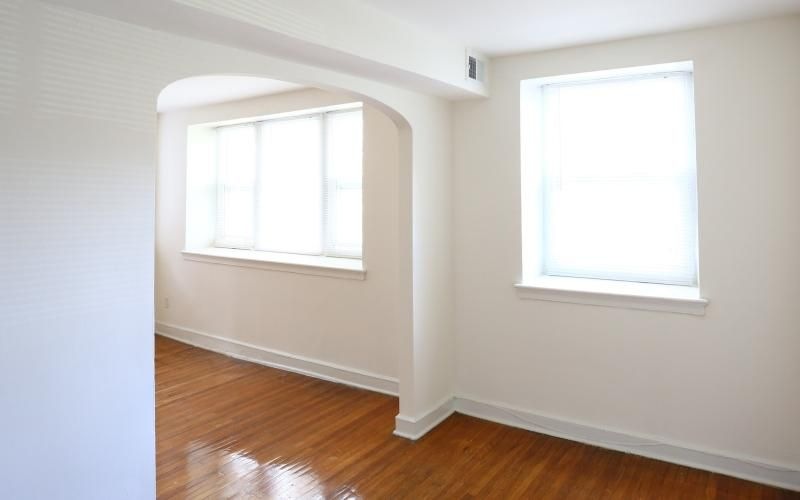 a room with a wood floor and white walls