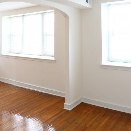 Settle into comfort at Wynnefield Apartments a room with a wood floor and white walls